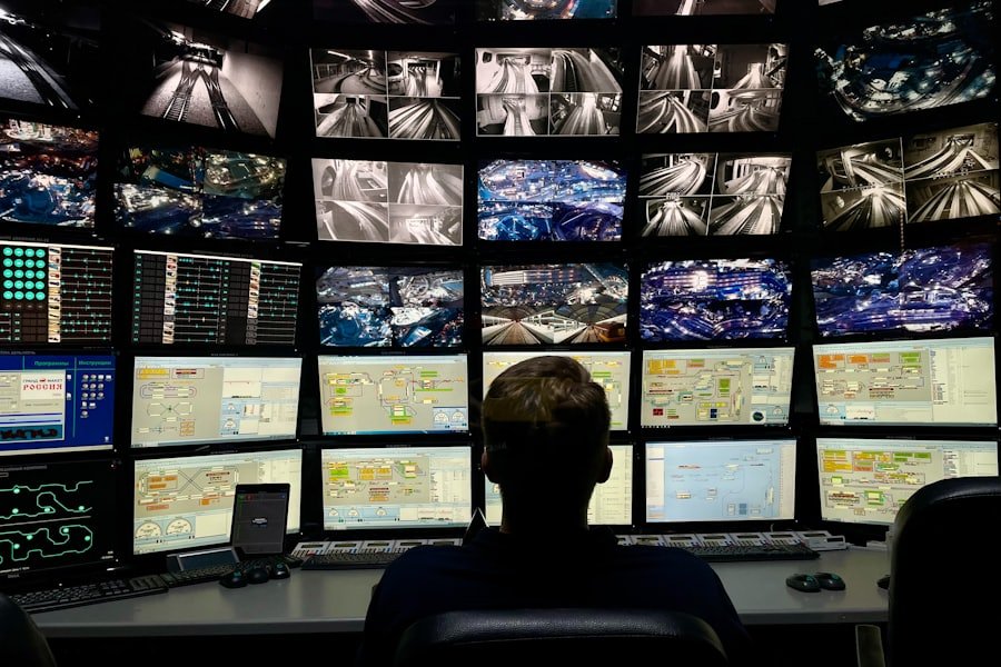 Operator monitoring a wall of CCTV screens in a control room